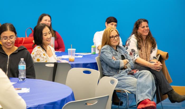 Audience members react to stories of challenge and growth at the EmpowerHER event.