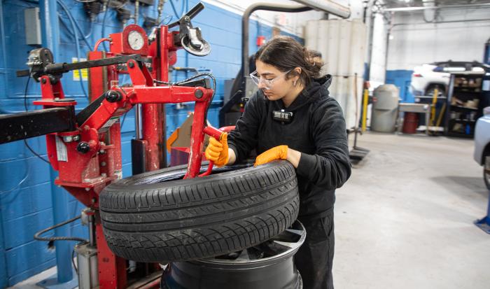 QCC alum Mariam Abdelwahab patching a tire at Harr Toyota