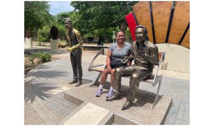 Sandra Hinds in in Valledupar, Colombia with a sculpture of musician Rafael Calixto Escalona Martínez.