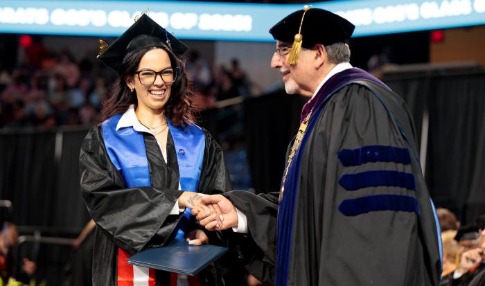 QCC President Dr. Luis Pedraja with a graduate at the 2026 commencement ceremony