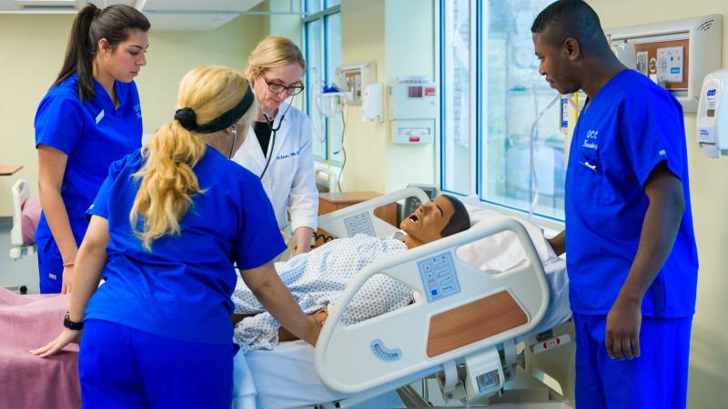 Nursing students work on a realistic nursing manikin.
