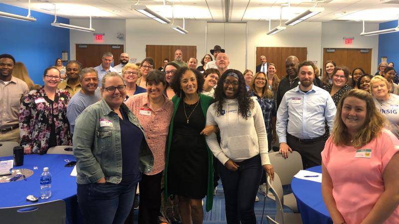 Maria Milagros (center in green) with QCC employees at the Staff Development Conference