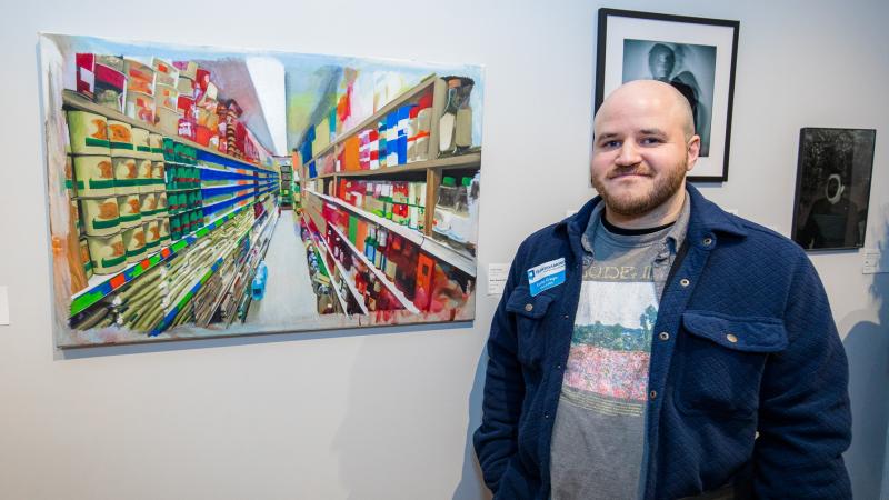Carlos Crespo with his painting "Silver, Sword, and Stone". Photo by Nathan Fiske.