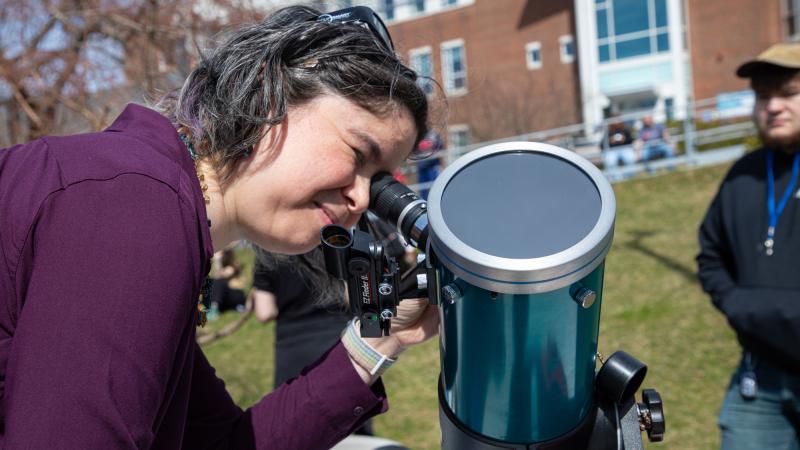 Professor of Integrated Science/Physics Andria Schwortz utilizing a telescope at the eclipse event.