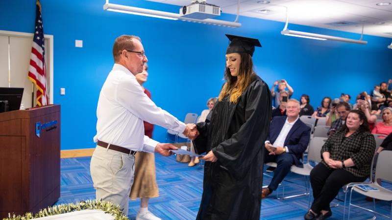 HSE/GED graduate Maria Snell receives a handshake from ACLC Case Manager Richard Nevalsky.