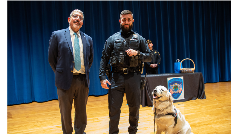 QCC President Dr. Luis Pedraja (left) and Community Resource Officer Nick Yacuzzi with Siggy sporting his new badge