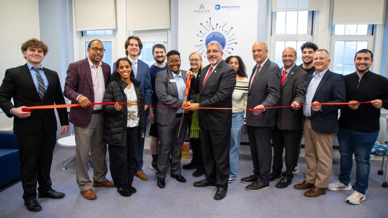 Director of the Auxilium Center for Entrepreneurship at QCC Rocky Knight and QCC President Dr. Luis Pedraja (center) cutting the ribbon with local officials, QCC trustees and QCC students.