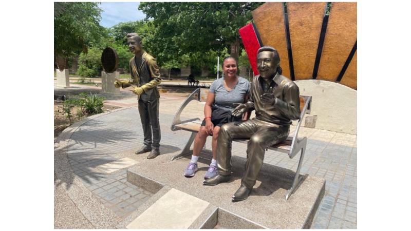 Sandra Hinds in in Valledupar, Colombia with a sculpture of musician Rafael Calixto Escalona Martínez.