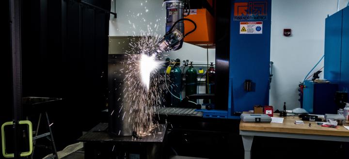 A laser cuts metal in a manufacturing lab