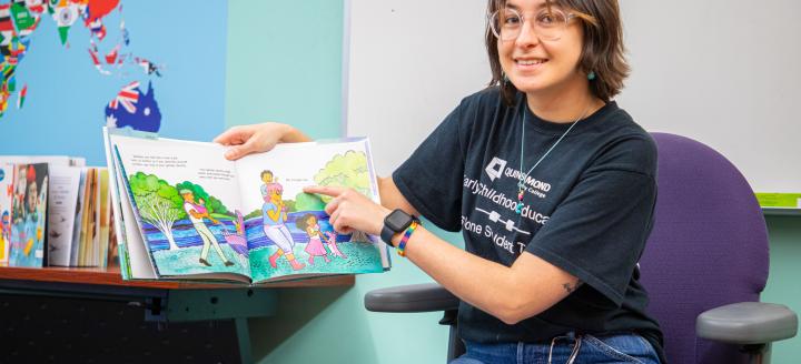 An ECE student reads a book to the class