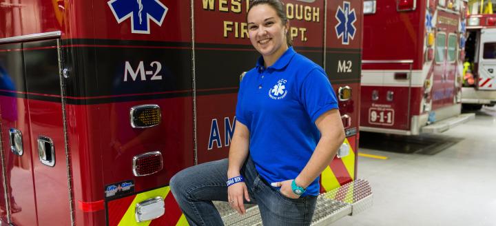 A female fire science graduate poses with a fire truck