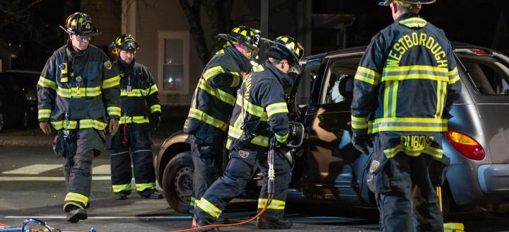 Firefighters work on a crashed car