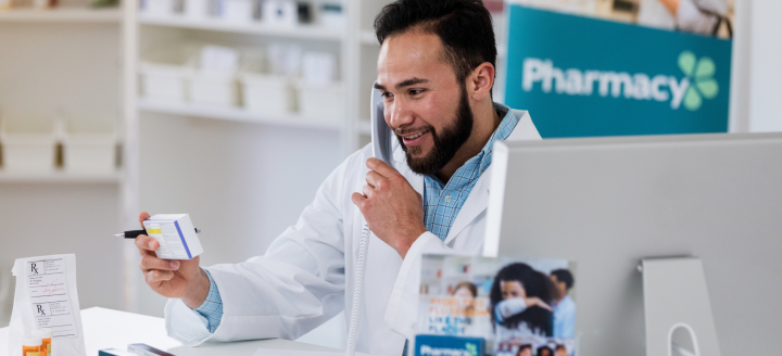 A man in a lab coat works in a pharmacy