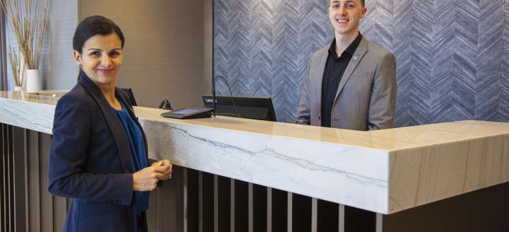 Hotel staff members at a reception desk in a hotel