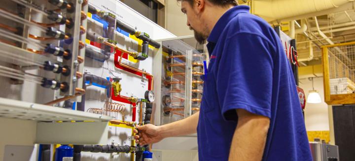 A student works with a HVAC setup in a lab