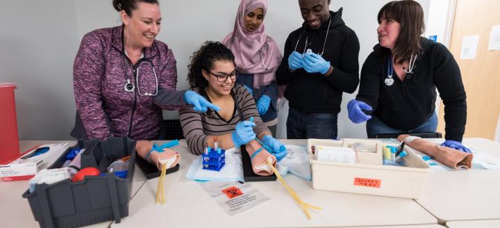 Students examine medical instruments in class