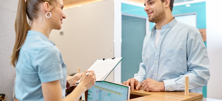 A secretary works at the front desk of a medical office