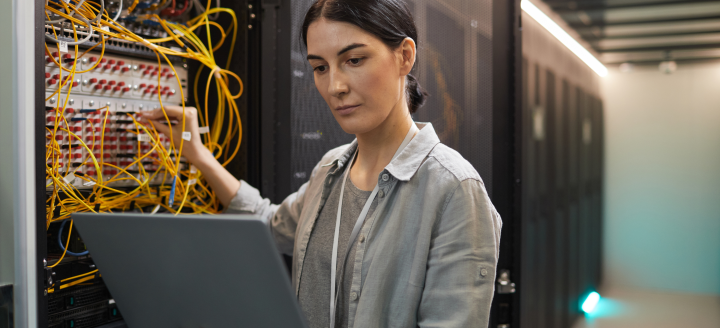 A woman works with a panel of wires