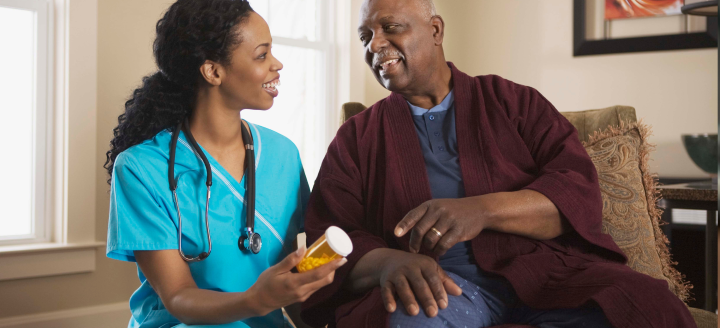 A nurse assists a patient in his home