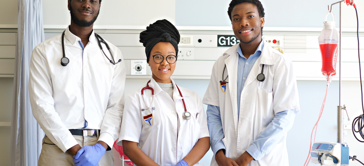 Three phlebotomists pose in a lab