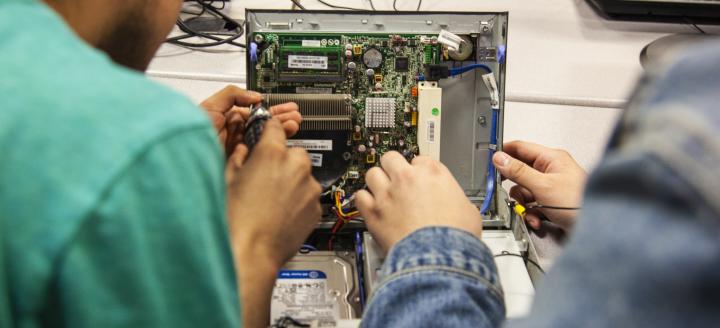 Students work on internal computer components in a lab
