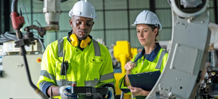 Two robotics technicians with robotic arm
