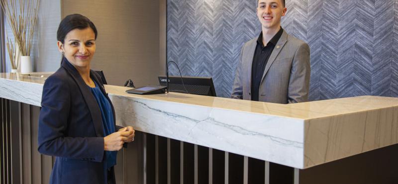 Hotel staff members at a reception desk in a hotel