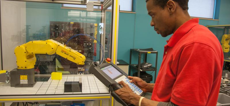 A student uses a robotic arm in the Advanced Manufacturing Lab